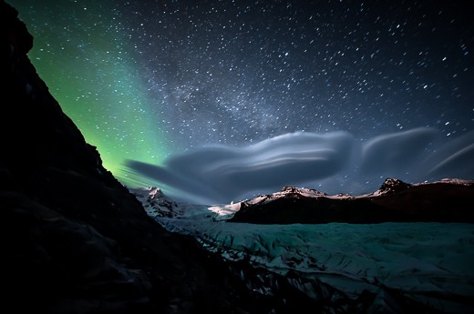 A lenticular cloud, the Milky Way and the Aurora Borealis above Skaftafell Park.