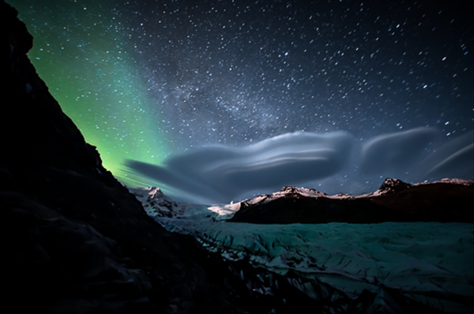 A lenticular cloud, the Milky Way and the Aurora Borealis above Skaftafell Park.