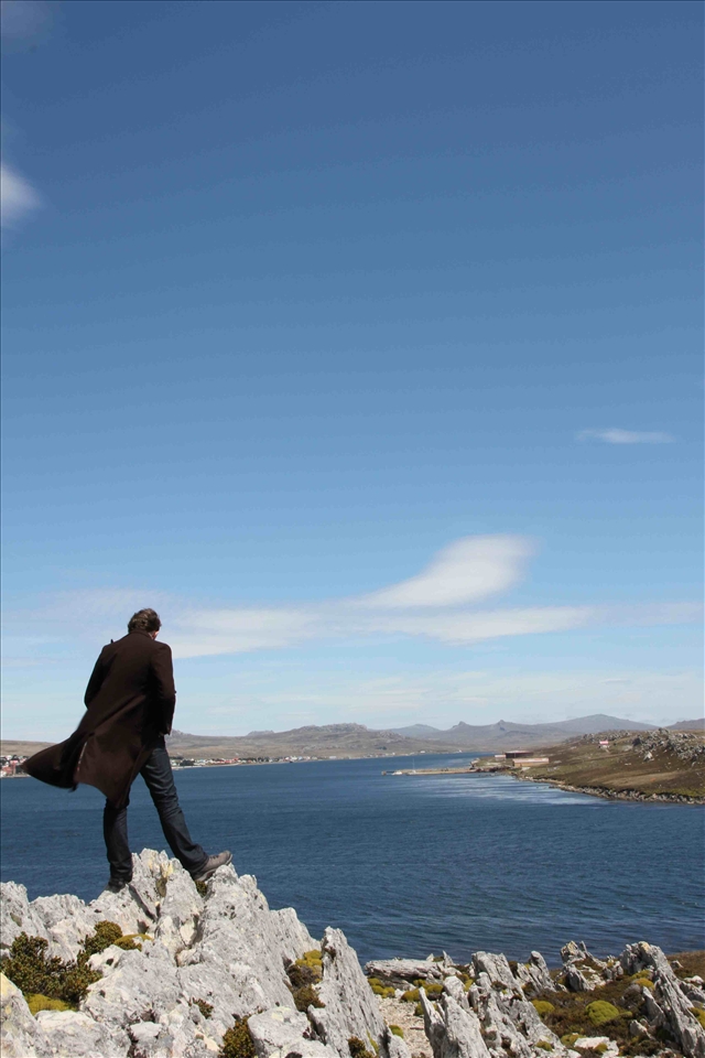 This photo shows the integration human civilization has made into the raw, untouched landscape of the Falkland Islands. The sharp rugged rocks are dangerous, yet the beauty of them, and the surrounding landscape, captures the attention and shows the contrast between the touched (the city in the background) and the untouched. 