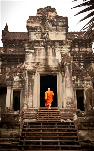 The monk was entering Angkor Wat, he appeared to be visiting for the first time. 

