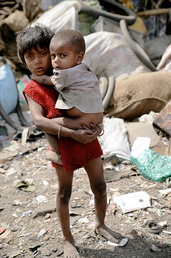 This young girl is left to care for her younger sibling while her parents are working as rag pickers. Children particularly girls are often the primary care givers of younger children, the elderly and the sick.  