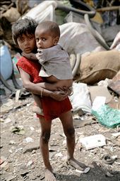 This young girl is left to care for her younger sibling while her parents are working as rag pickers. Children particularly girls are often the primary care givers of younger children, the elderly and the sick.  : by camillenelson, Views[256]