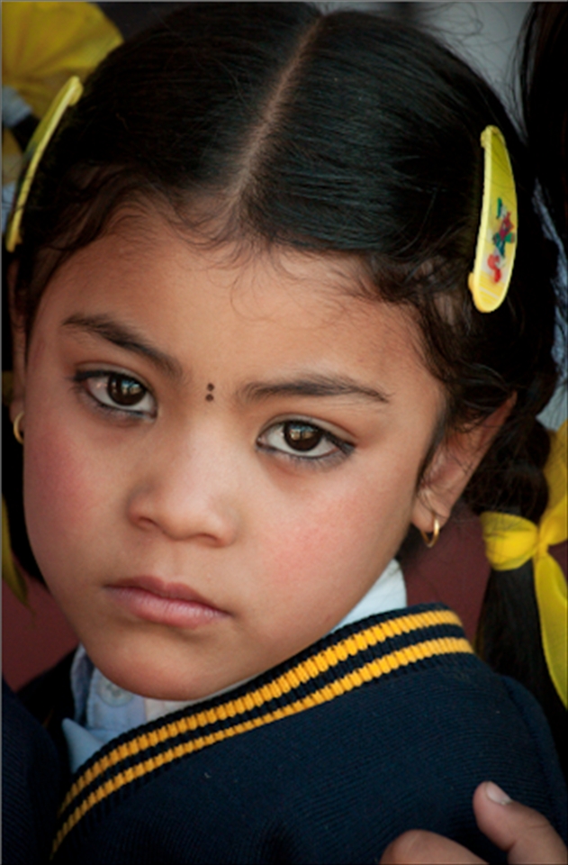 A young Nepalese girl, dressed in her school uniform. She attended the same private school in Kathmandu that the orphans I worked with went to, many of them on generous scholarships. Like many children in Kathmandu, the kohl around this girl's eyes is not only applied for aesthetic reasons but to protect her against the evil eye.  