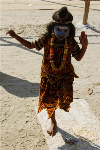 A child dressed up as the Hindu God Shiva poses for alms as pilgrims pass her by on the sandy riverbank. Shiva is popularly depicted with a greyish-blue skin palor & dressed in tiger skin. He is one of the three most influential denominations in Hinduism. The auspicious Maha Kumbh festival takes place once in 12 years and attracts the rich and poor alike.
Maha Kumbh Mela, Allahabad, India 2013