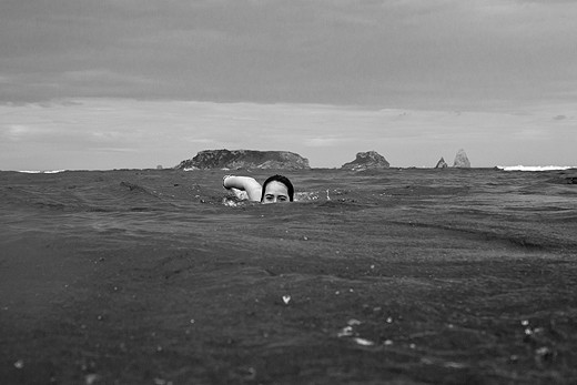 A girl swimming between the Medes island and L'Estartit beach