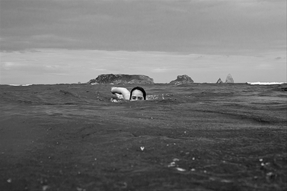 A girl swimming between the Medes island and L'Estartit beach