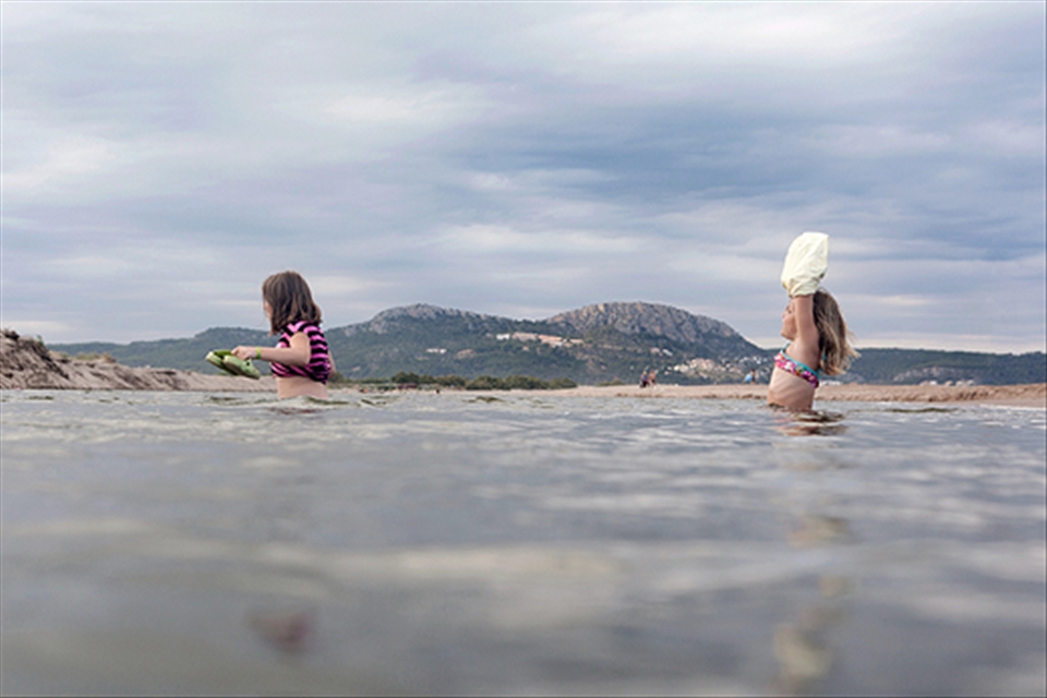 Twoo girls crossing the Ter river in Pals beach