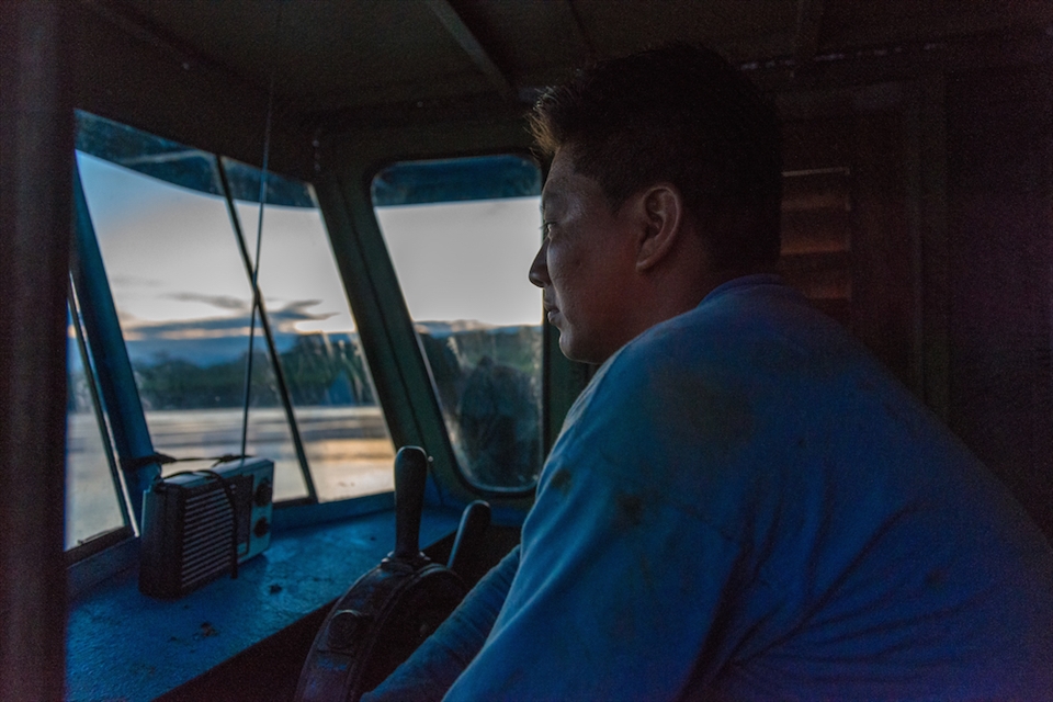 The Captain of El Junior boat steers the boat as it goes up the Ucayali river 