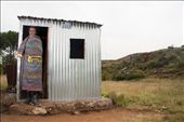 This Basotho young man poses next to his improvised shack.  
Inside, there is only space for a long banch and wood stove, to help keep him warm through out the day. 
He is also a cattle herder and he is wearing a blanket, that he did the embroidering himself. : by carmels, Views[1122]