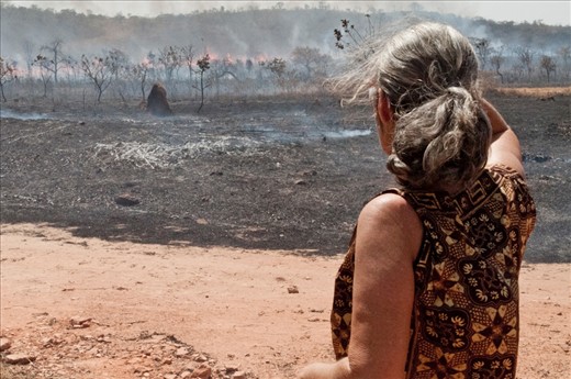 A local dweller watches as the fire eats away rapidly at the grasslands.