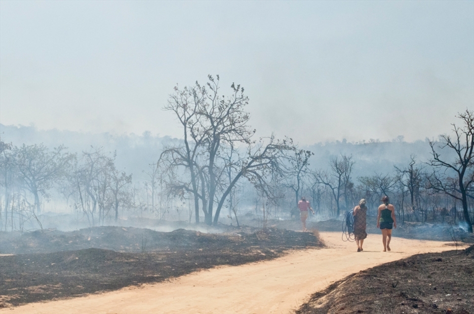 Locals do their best at keeping the fire away from their homes, using garden hoses and buckets.