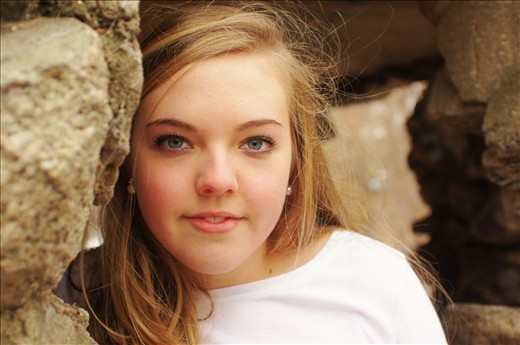 Lady stands in an abandonded and distressed stone hut resting on the Rum River