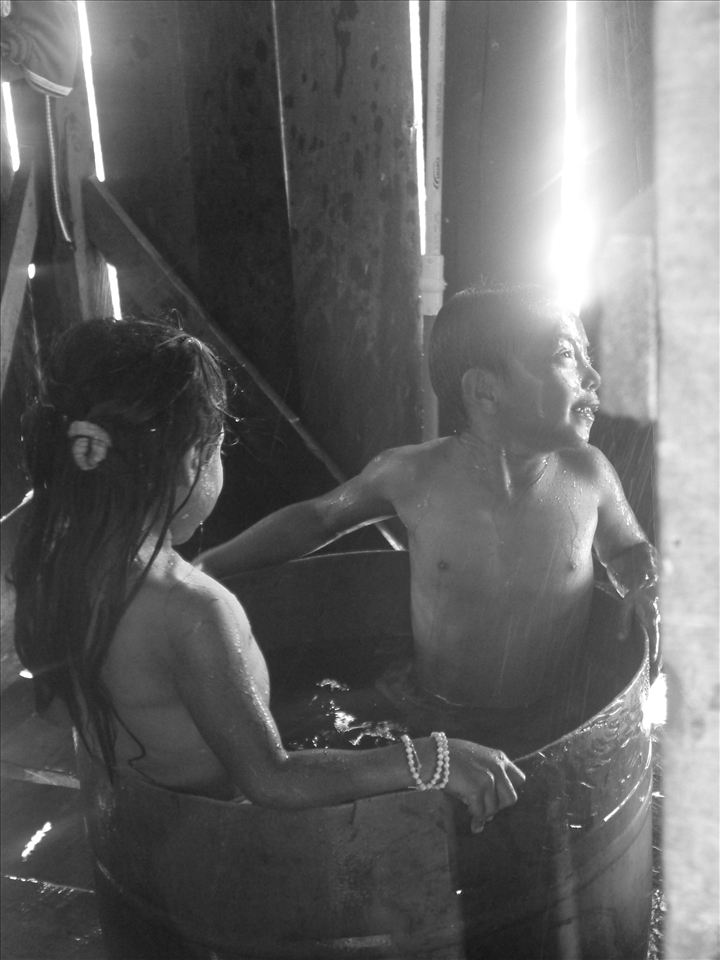 Brother and sister happily share a bath in their makeshift bathtub