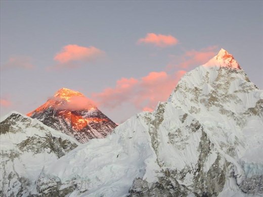 Mount Everest attempts to hide but is lit by the sun at dusk. The giant sleeps.
