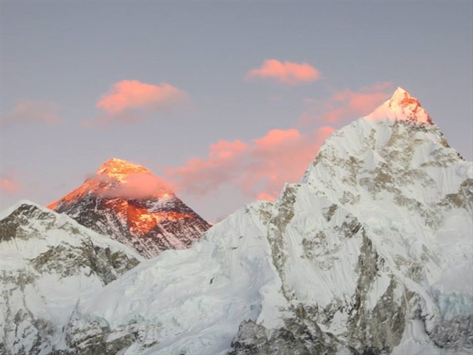Mount Everest attempts to hide but is lit by the sun at dusk. The giant sleeps.