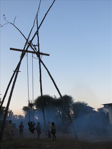Village children play at dawn on a bamboo swing created for Dashain Festival.