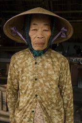 This almost lifeless woman keeps up tradition wearing a conical hat, matching her strong yellowing skin and dowdy shirt. She looks almost like a chiseled sculpture. The tired look perhaps one of her last!
: by cate5, Views[352]