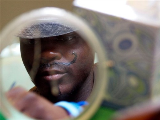 Volunteers do face painting on children and to themselves.