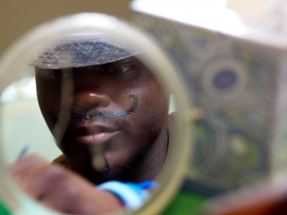 Volunteers do face painting on children and to themselves.