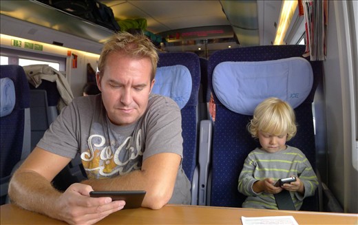 Like Father like Son - both engrossed in their electronics on train to Luxembour