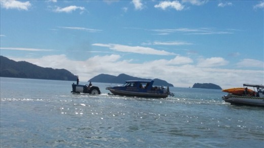 Tractor pulling the water taxi boat and trailer into the sea