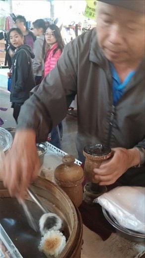 He's making a sweet rice flour dumpling with a bit of sugar in the middle- black and brown sugars, I think made from taro 