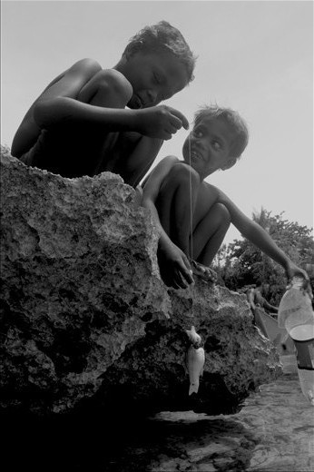 Ati kids catching fish. Fishing is the Atis' main source of living. According to them, their seas were filled with plenty of fishes before tourists started flocking to their island.