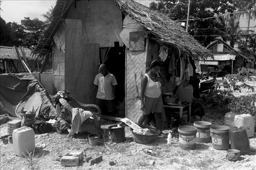 An Ati couple moving into their new house in the tribe's new settlement site. This small piece of land where 50 Ati families built their houses on (and had to make do with) is still under dispute. The developer of a hotel being constructed nearby is laying claim to it and has sought for a temporary restraining order from a local court to stop the Atis from occupying this land.