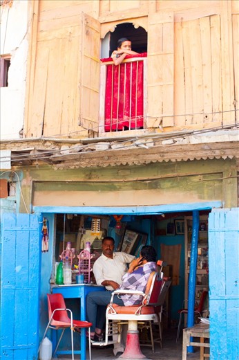 Captured in the by lanes, a young boy gazes out of his home above a barber-shop. The way the picture is a story of 2 halves struck me immediately. I also love the vibrant colours in the frame.