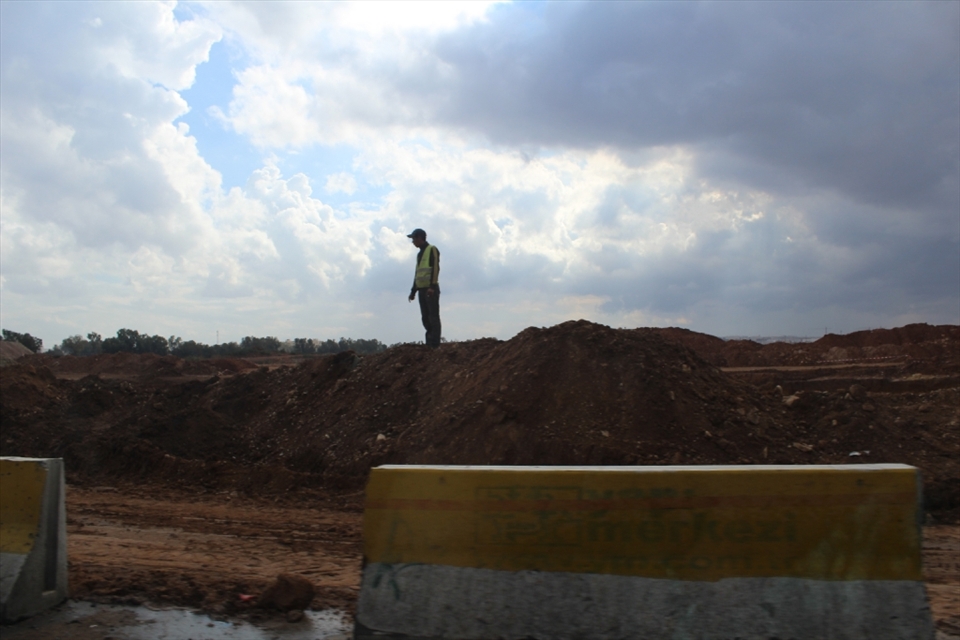 A builder in the top of the pile he dig out of the ground