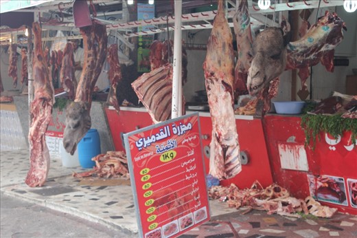 The Butcher with Camel hanged in his meat hanger, with a big list of prices next to it, a way of buying meat, traditional but effective.