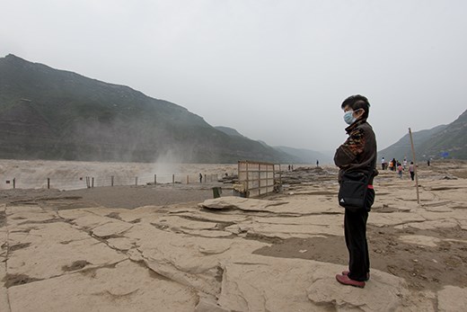 The Hukou waterfall is the largest on the yellow river, and a popular tourist site. Even in rural China, there is still a great deal of pollution, evident here with the dust mask worn. The waterfall spray containing dust and dirt picked up along route. 