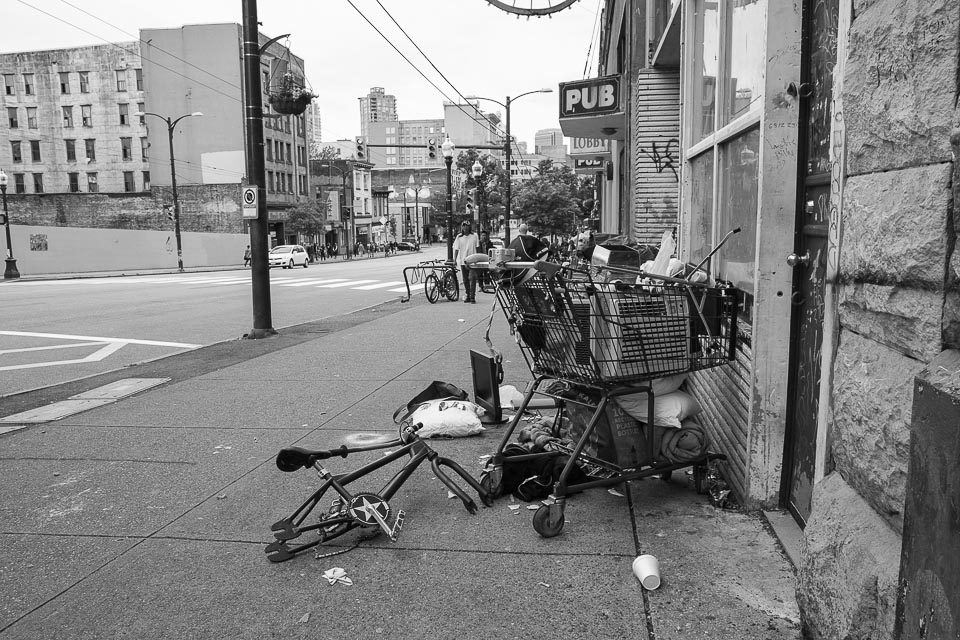 The DTES has traditionally been home to the disenfranchised and poor residents of Vancouver.  At almost 70%, the proportion of low-income individuals and families in the DTES is almost triple that of the regular Vancouver populace.  By engaging in practices such as  “Bining” and “Dumpster Diving”, residents find ways to subsist their limited income.  Shopping carts filled with dumpster treasures, such as the one pictured above, are a trademark of the DTES.