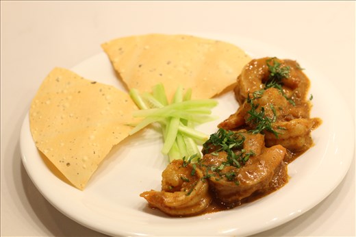 Goan Prawn Curry plated with cucumber salad and crisp papad