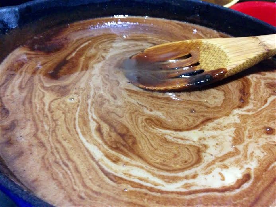 Egg and milk mixture blending with the dry ingredients in the cast iron skillet.