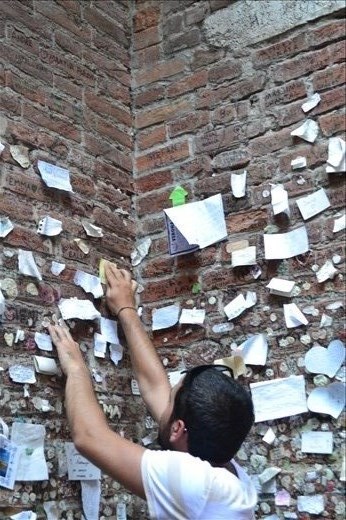 Man leaving a note by Juliette's balcony, Verona