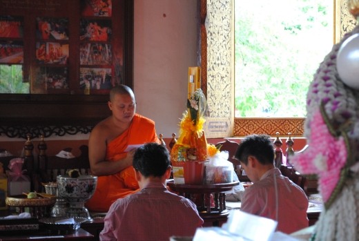 Two guys giving offering to monk