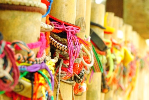 People leaving wristbands by grave site (Killing Fields)
