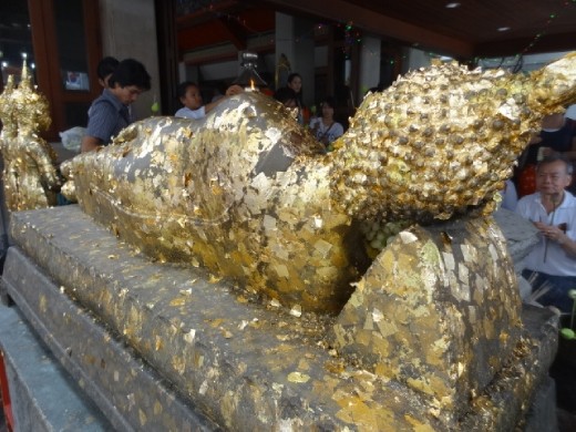 People buy gold leaf and press it against the Buddha.