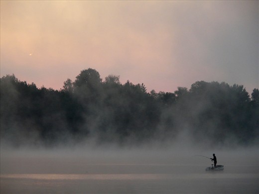Early angler peacefully lost in the act