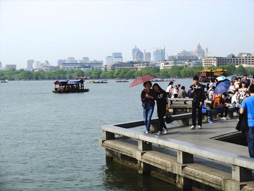 Hangzhou hovers in the background, locals pose unasked