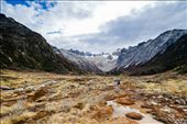 Laguna Esmeralda, Ushuaia, Argentina - On my way to Laguna Esmeralda, you can see how glaciers are melting down as climate is warming up. Everything that looks like pure rock in the mountains was once a big glacier, all its left is that tiny piece of ice at the very top. The hiker is crossing what used to be a massive river coming down from the lagoon at the bottom of the glacier (Laguna Esmeralda), all its left is this spongy tundra and the little river at the left. Still shows how vast the landscape in Patagonia can be.: by chrisnmn, Views[759]