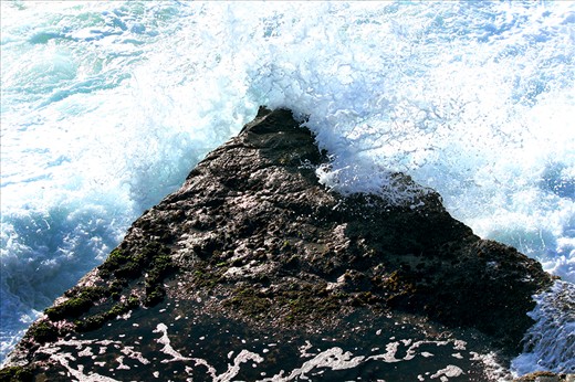 The waves throw themselves violently against ancient rock.
