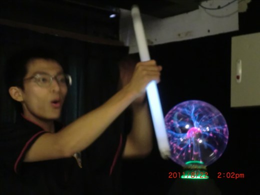 He is talking and doing a demonstration on electricity.