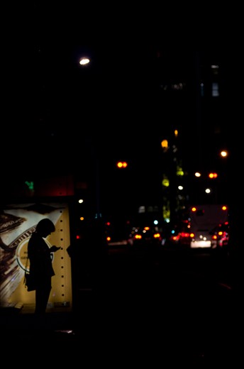Fiddling with her phone while waiting for the bus, if buses didn't pull into the
