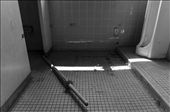 A kendo shinai rests on the floor of a boy's bathroom adjacent to the gymnasium.  Even though the buildings have been mostly cleaned out, items still remain as if to serve as an eerie reminder of the times once enjoyed here.: by cknipp, Views[431]