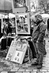 A man stands beside his artwork at Place du Tertre. He is one of the many artists who flock to Montmartre's most popular square in order to sell homemade masterpieces to passing tourists.: by claires, Views[265]