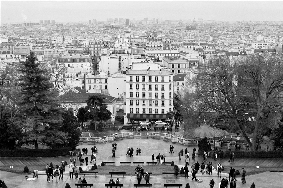 From the entrance of Sacré Coeur, Paris's expanse seems infinite. Many visitors scurry down the steps towards the center of Montmartre, while others stop to wonder at the rooftops.