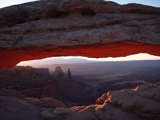 Mesa Arch lighting up at sunrise, in Canyonlands