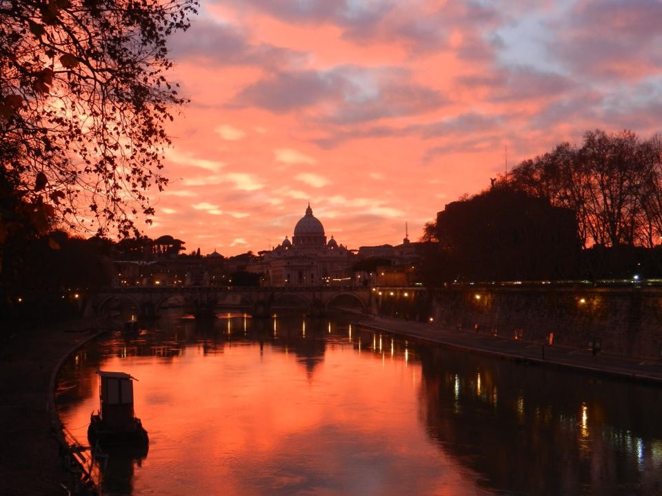 Rome along the Tiber River, accompanied by illuminating sunset.